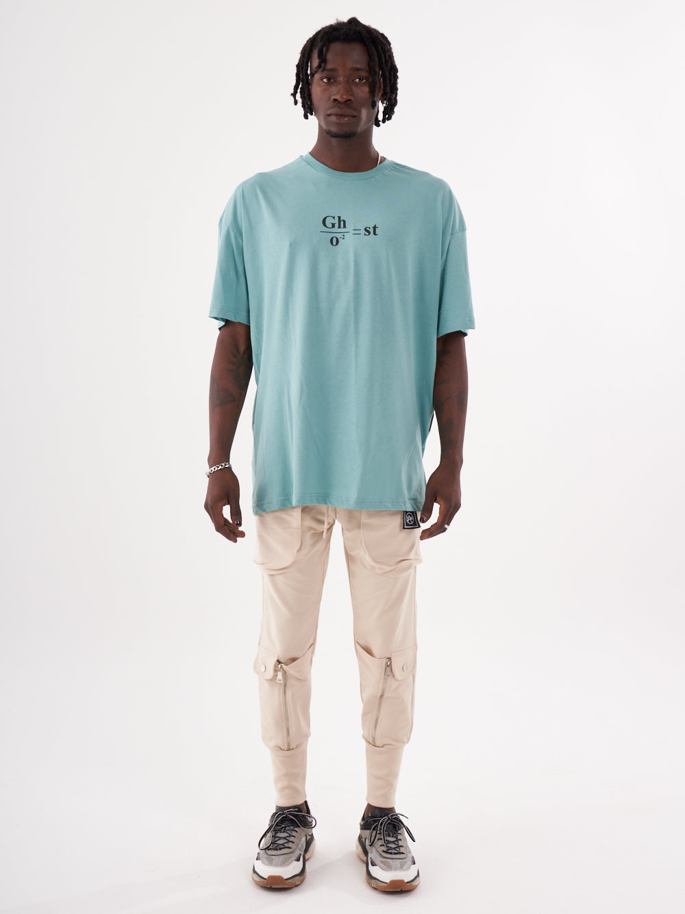 A man wearing a GHOST t-shirt and tan pants.