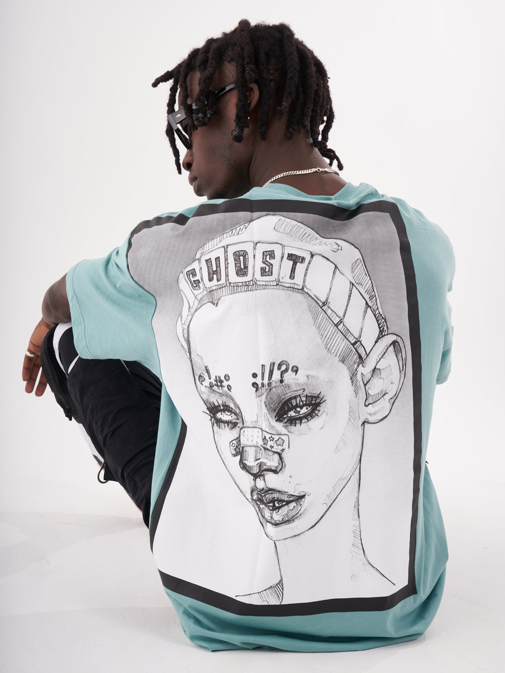 The back of a man wearing a GHOST T-SHIRT with a drawing of a woman.