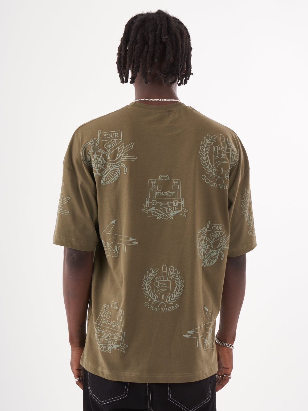 The back view of a man wearing an olive color VICTORY oversized t-shirt by Sernes Streetwear