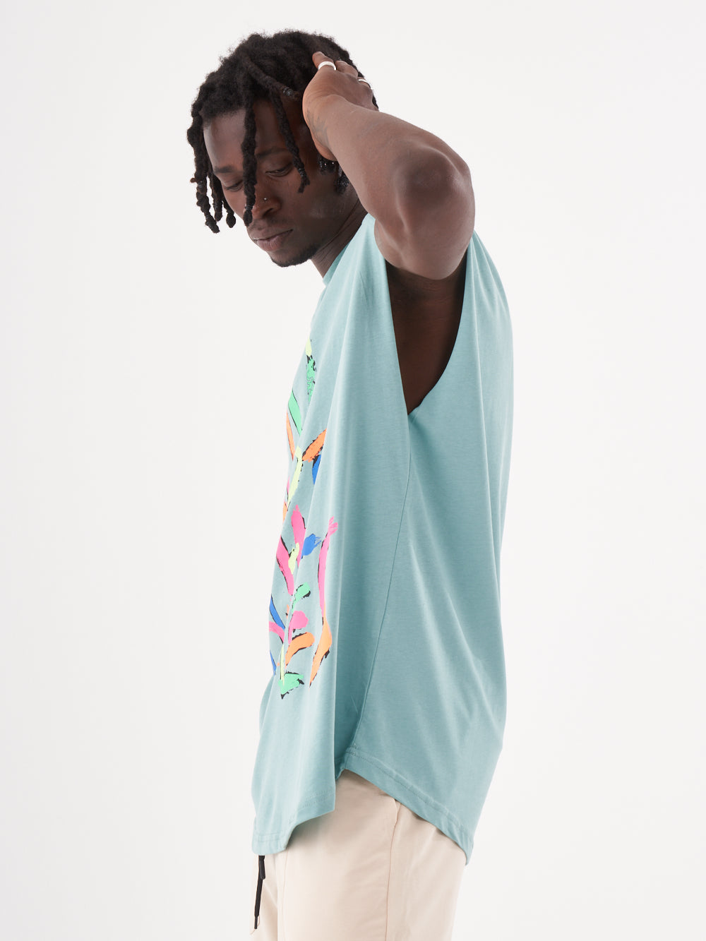 A man wearing a REBELLION T-SHIRT and white shorts.