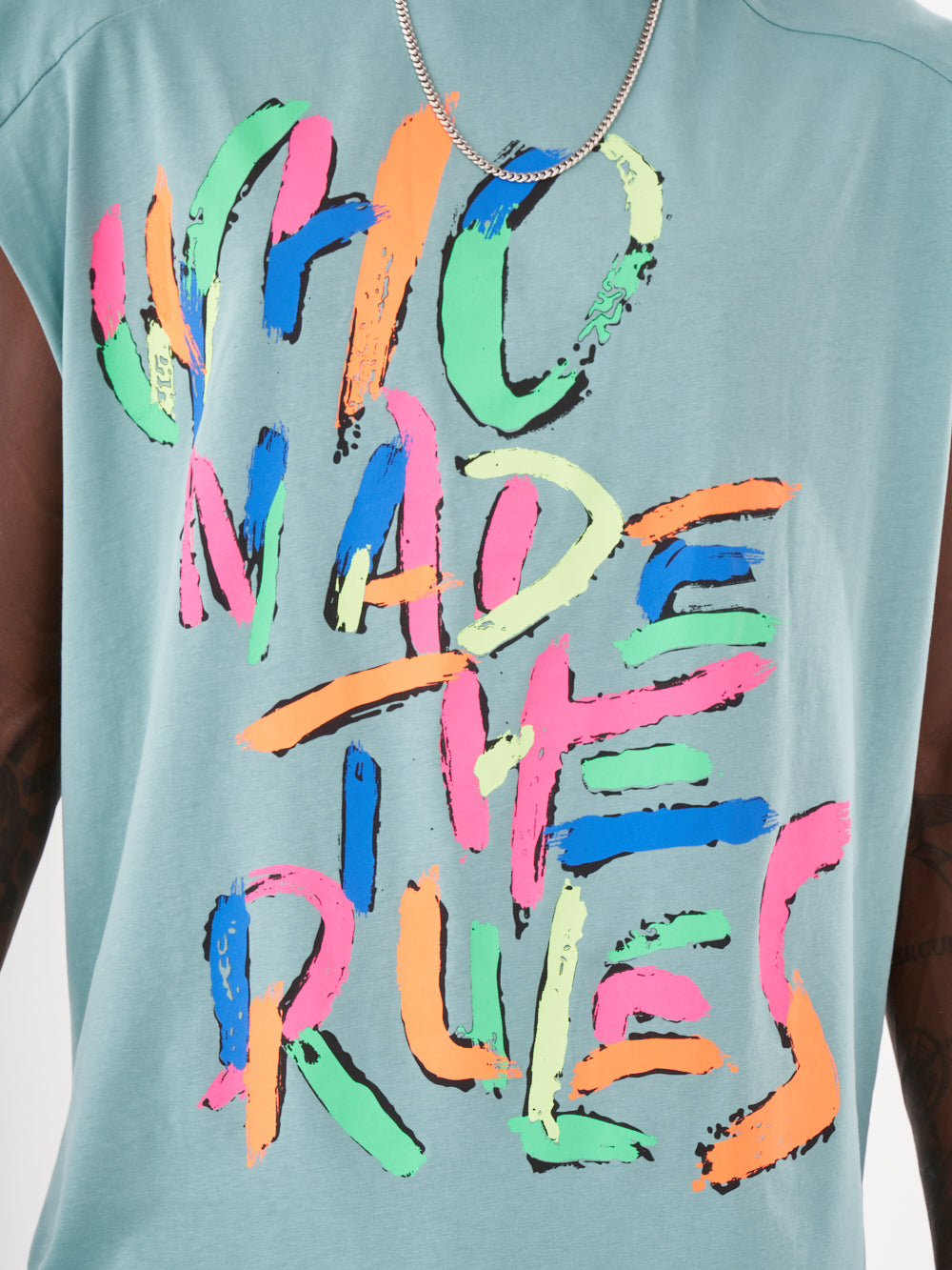 A man wearing a blue REBELLION T-SHIRT that says who made the rules.