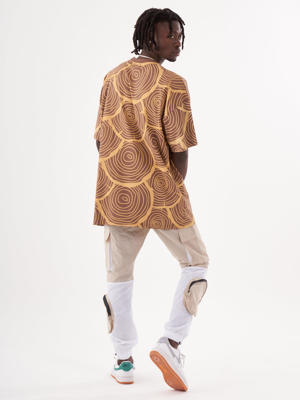 A man wearing a STEPPE t-shirt and white pants.