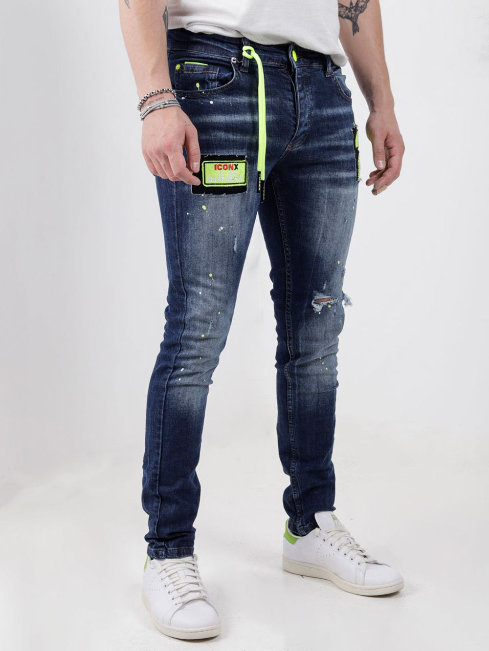 A man wearing a pair of PHOSPHORUS jeans with neon accents.