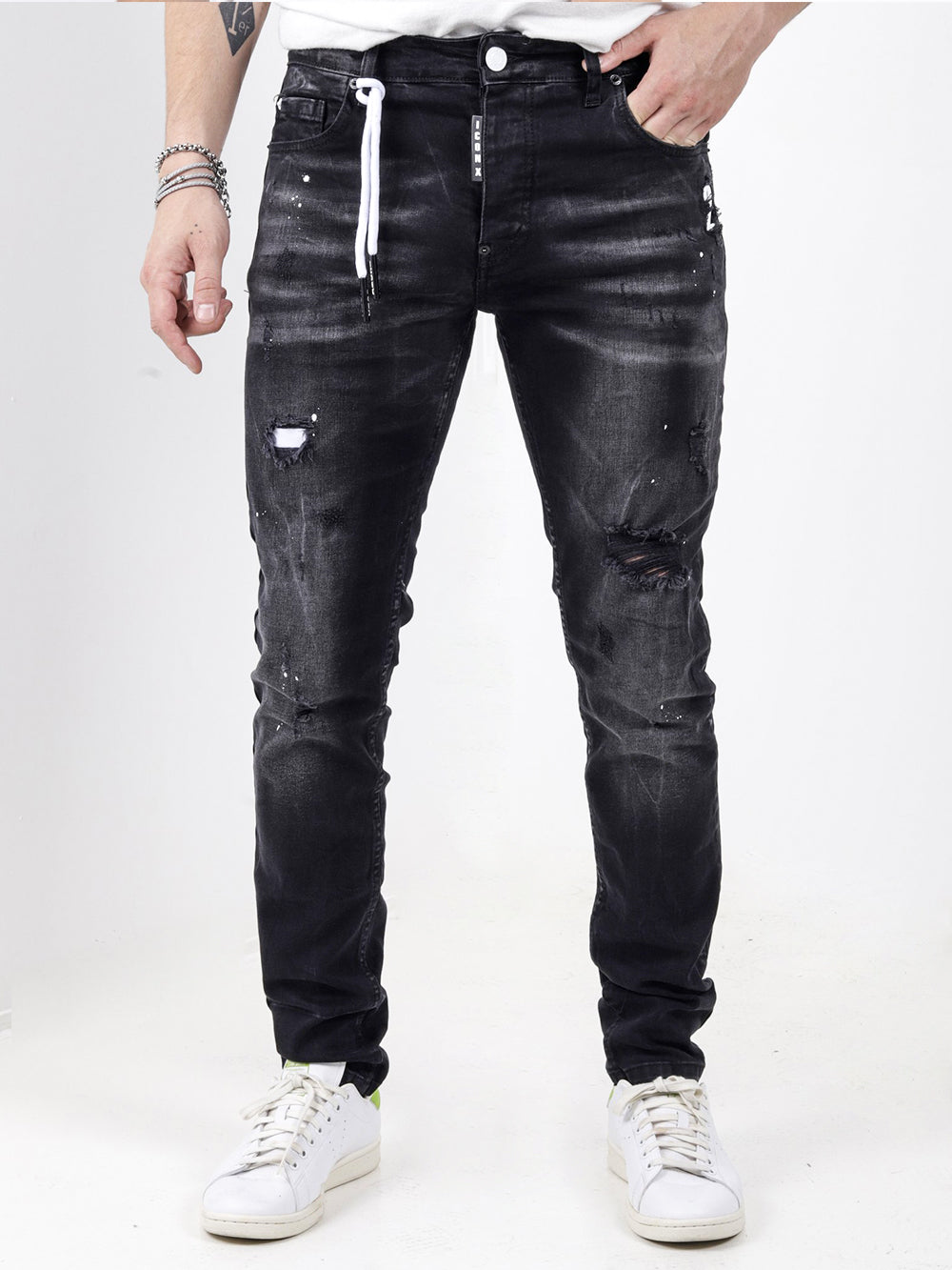 A man wearing black jeans and a white MODERO t-shirt.