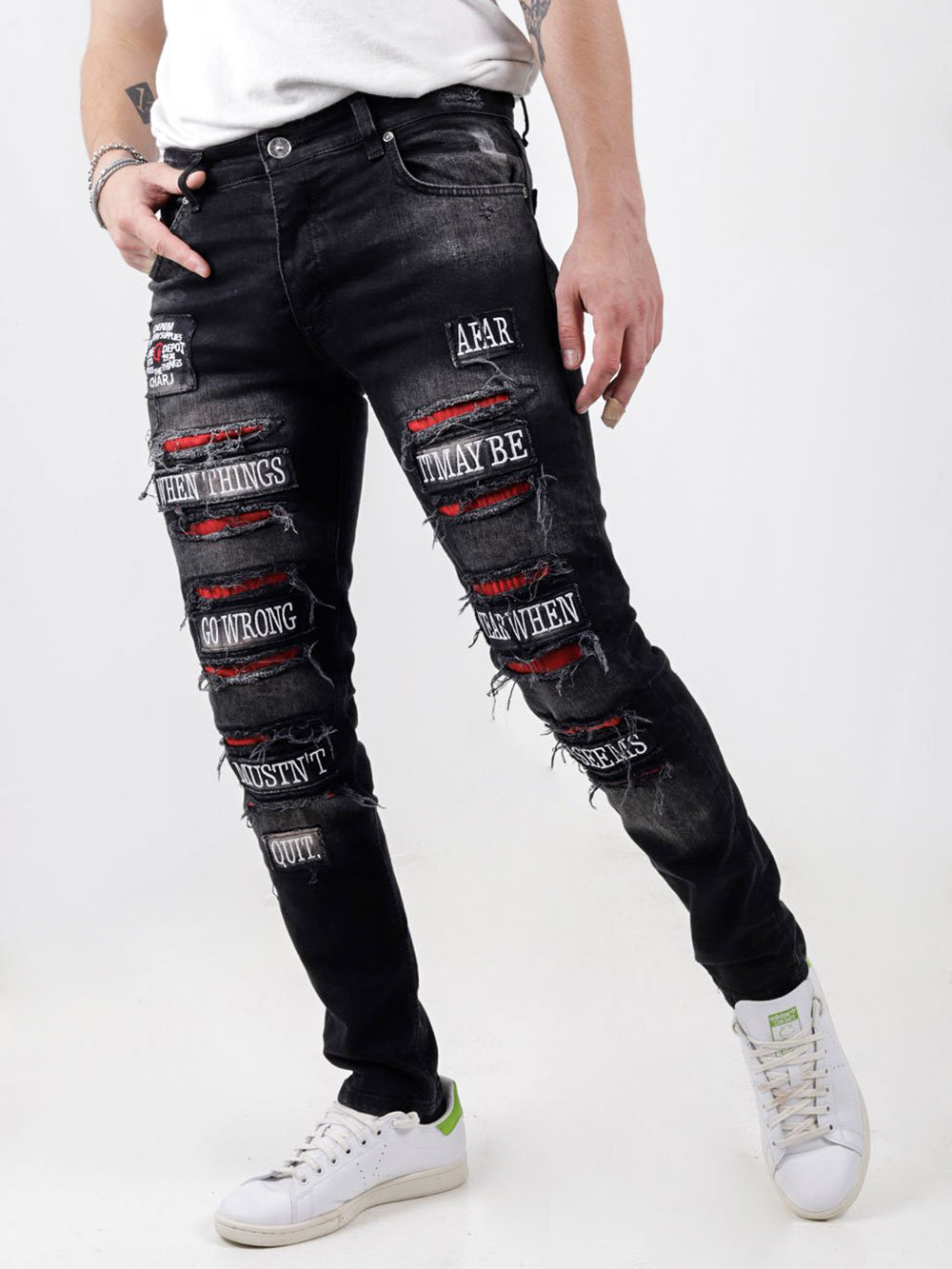 A man wearing ripped jeans and a white t-shirt.