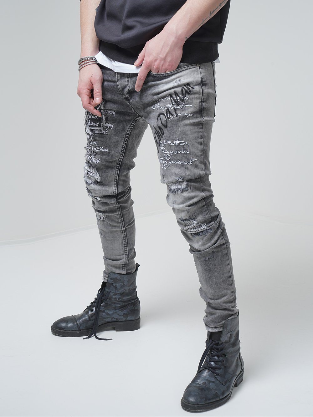 A man wearing ripped skinny jeans and a black hoodie named LONDON.
