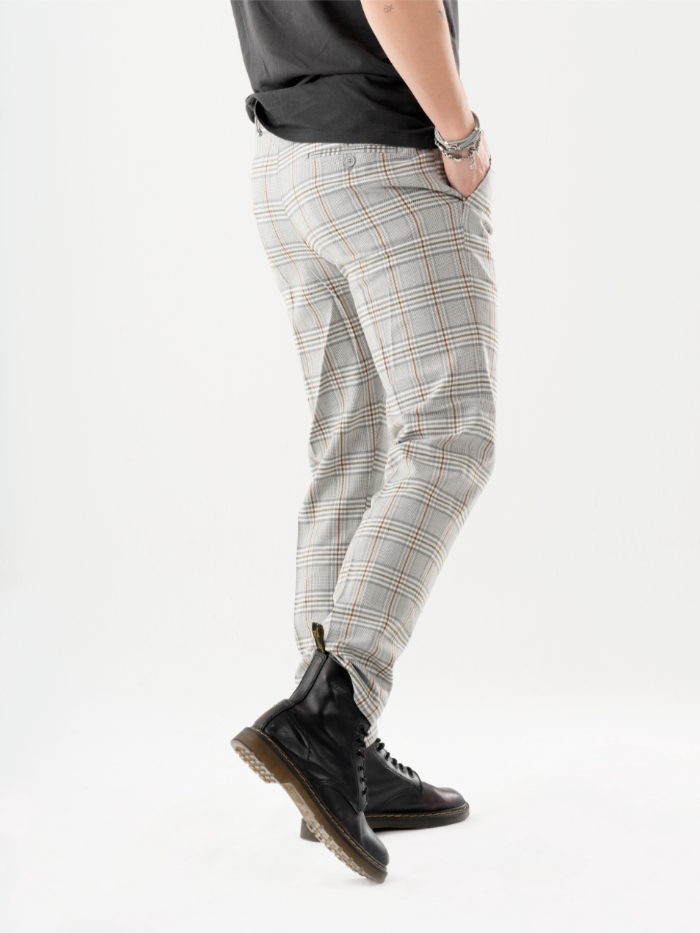 A man in a t-shirt and ALORA PANTS is standing in front of a white background.
