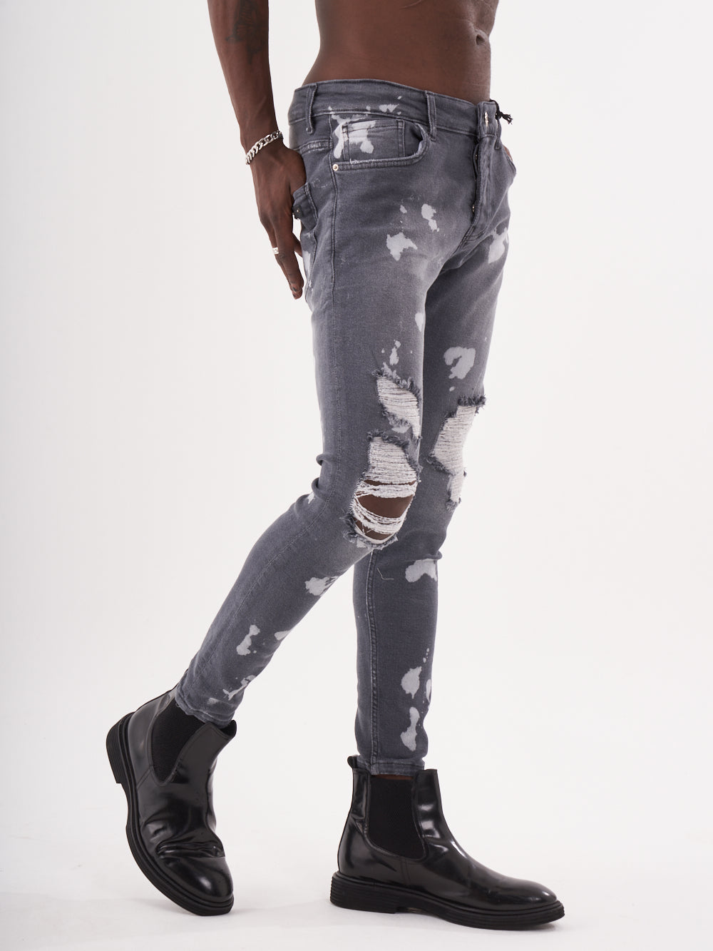 A man wearing the product name MAVERICK jeans and black boots.