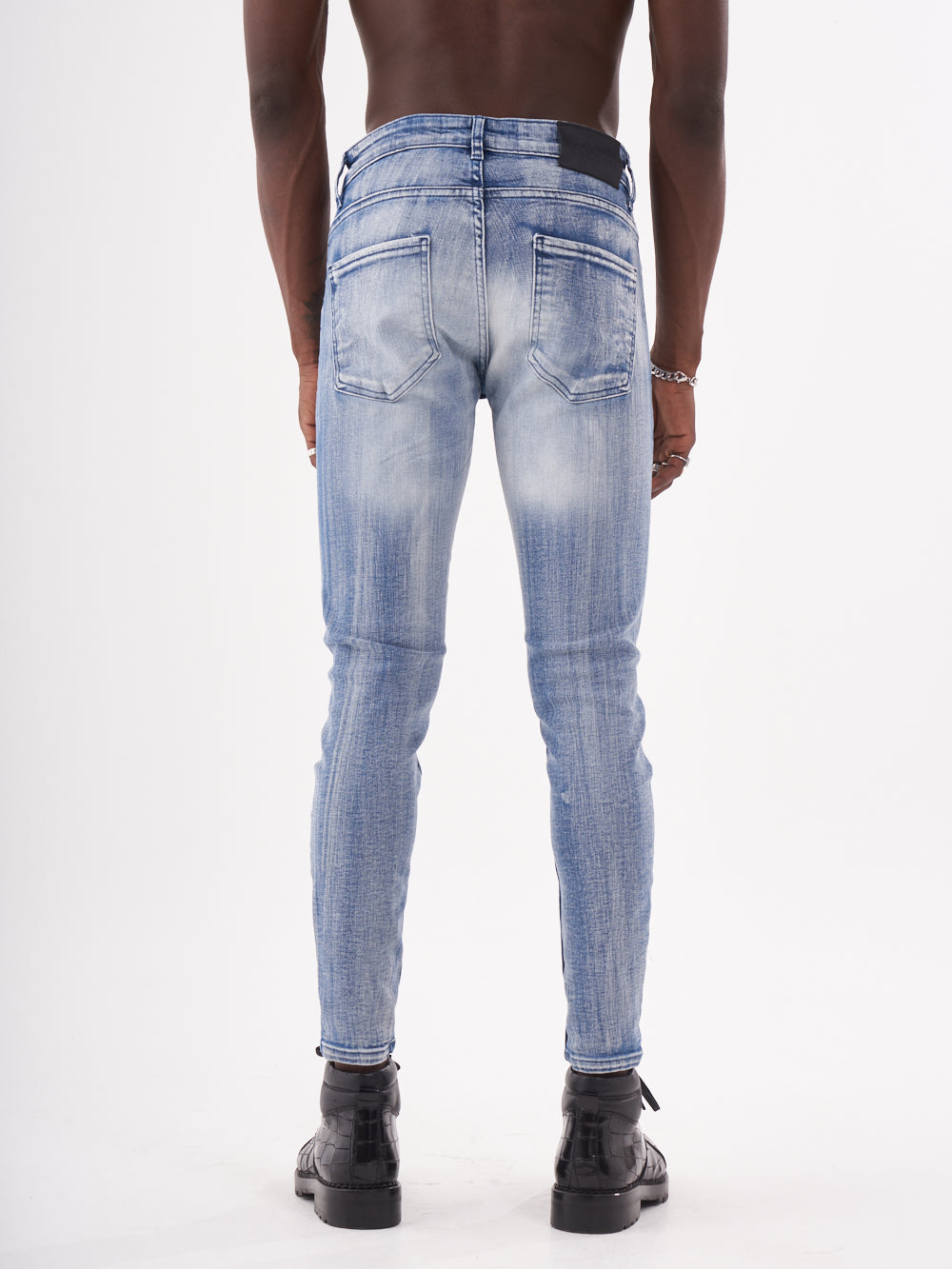 The back view of a man wearing MUTANT jeans.