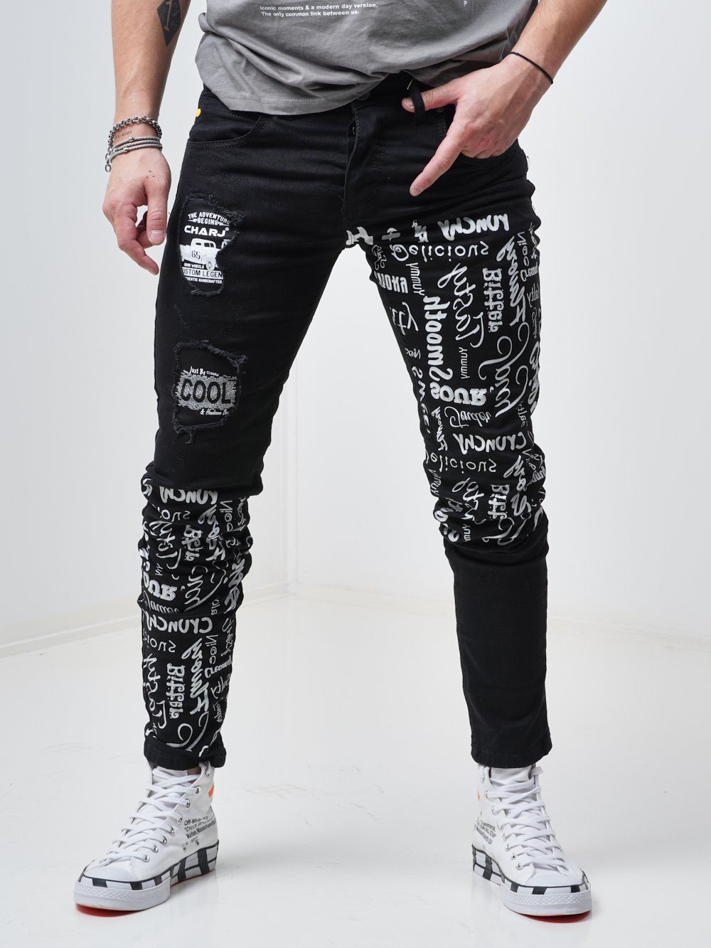 Front shot of a man wearing the skinny fit streetwear jeans called THE MECHANIC by SERNES with lots of text printed on it