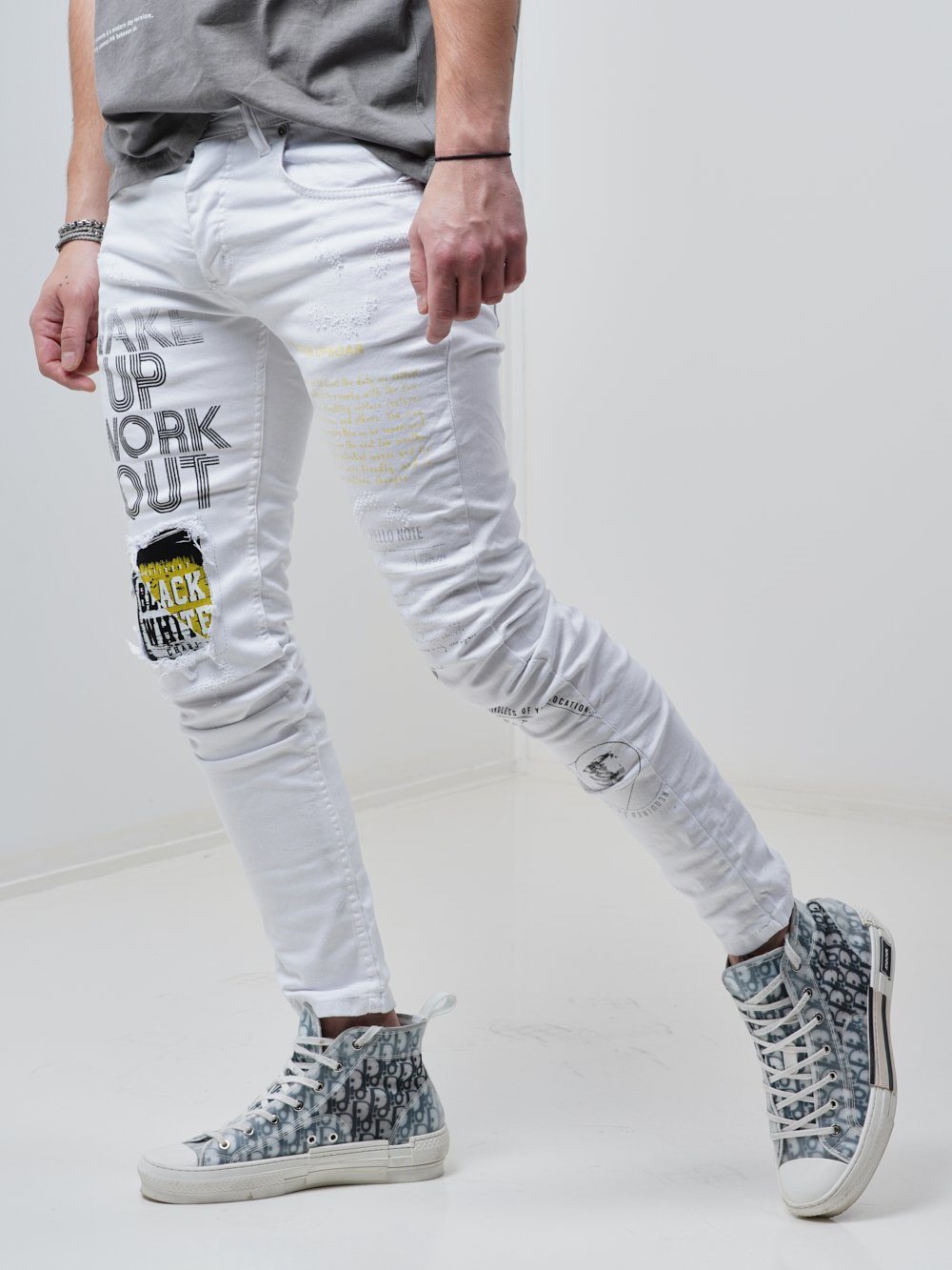 Side shot of a man sporting the Skinny-fit Ripped Jeans called WINGMAN in white color by SERNES Streetwear
