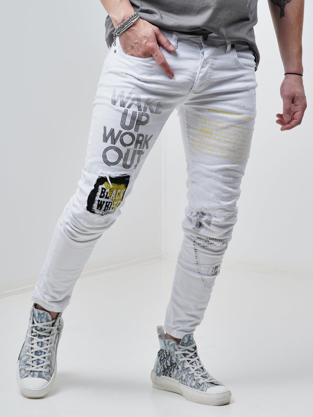 Side shot of a man wearing the Skinny-fit Ripped Jeans called WINGMAN in white color by SERNES Streetwear