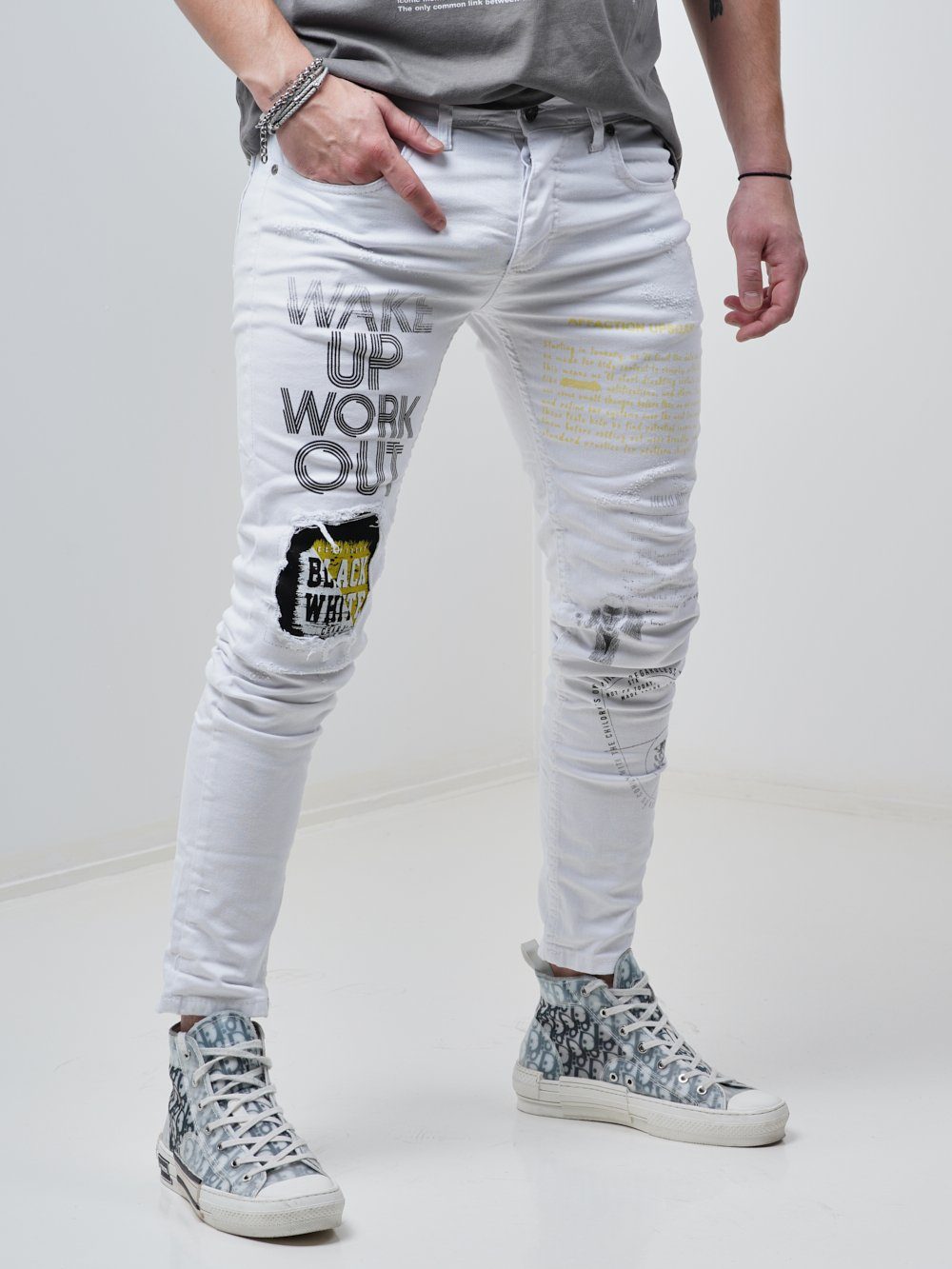 Side shot of a man sporting the Skinny-fit Ripped Jeans called WINGMAN in white color by SERNES Streetwear