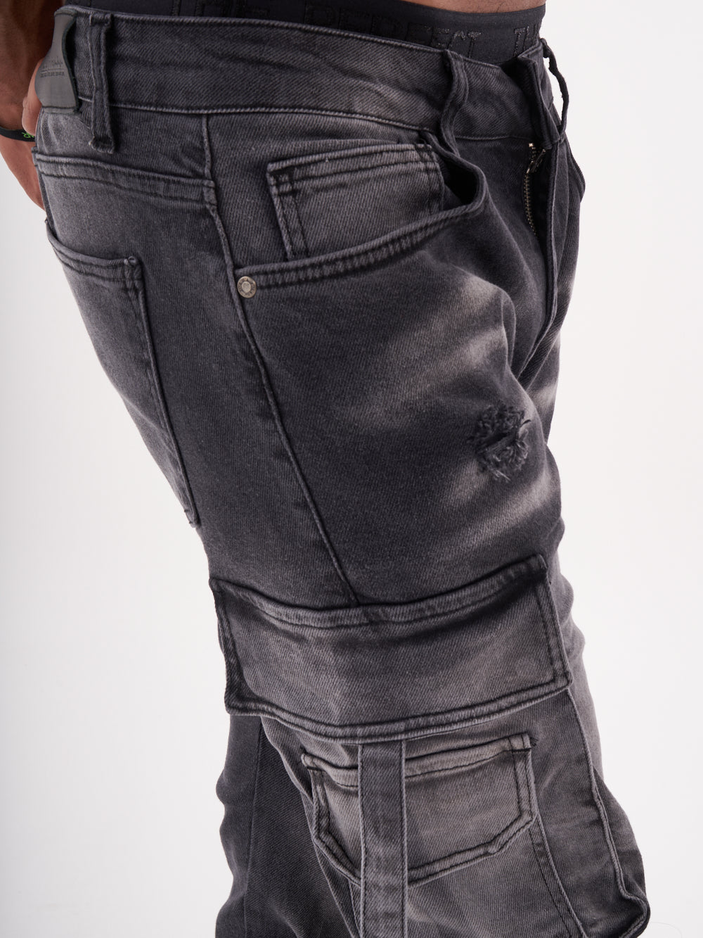 A man is wearing a pair of black HIPSTER cargo pants.