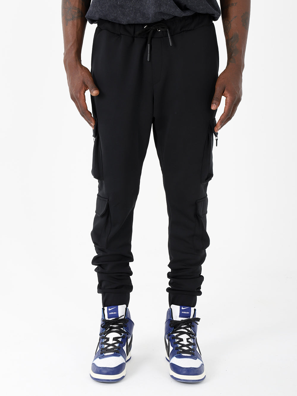 A man wearing VENTURA JOGGERS with adjustable ankle cuffs and sneakers.