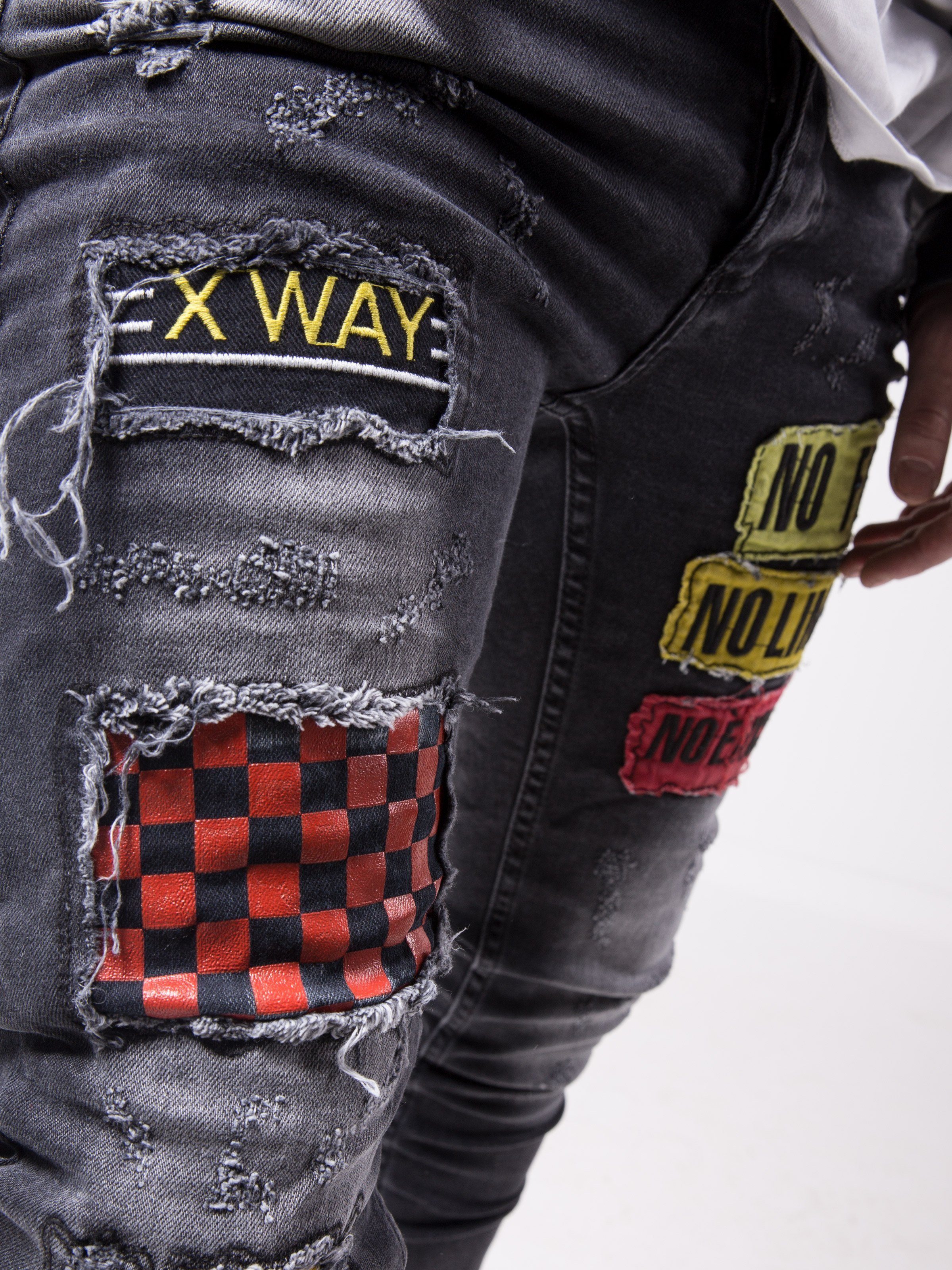 A pair of FEARLESS skinny fit jeans with a patch that says x way, made from elastic fabric for a smooth feel.