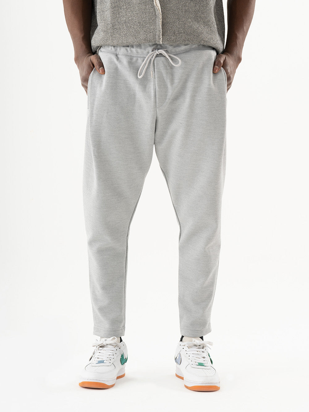 A man wearing comfortable SERENE JOGGERS and a cozy grey hoodie, perfect for everyday wear.