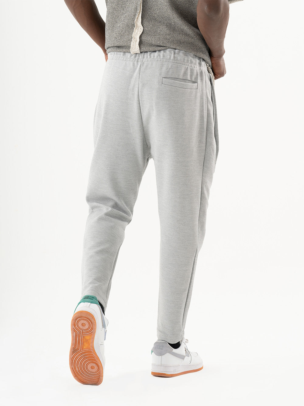 A man wearing SERENE JOGGERS and a pair of sneakers, perfect for everyday wear.