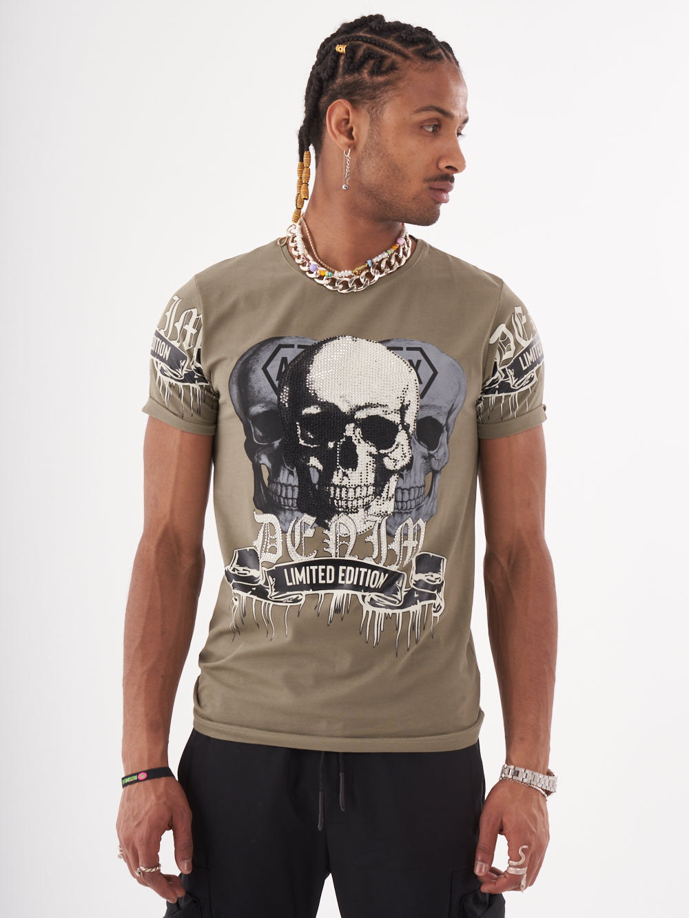 A man wearing a SKULL CRUSHER T-SHIRT | GREEN with skulls on it.