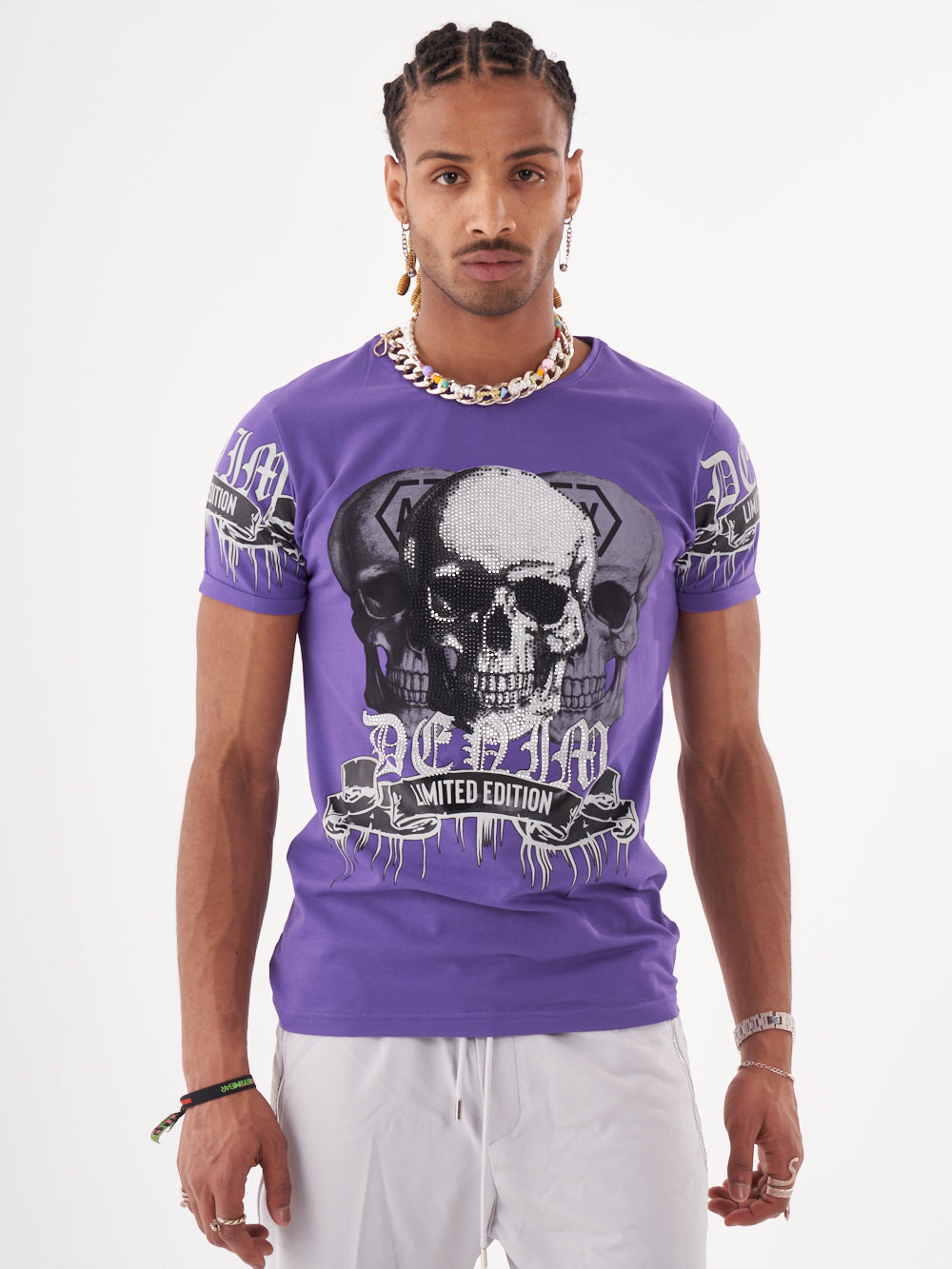 A man wearing a SKULL CRUSHER T-SHIRT | PURPLE with skulls on it.