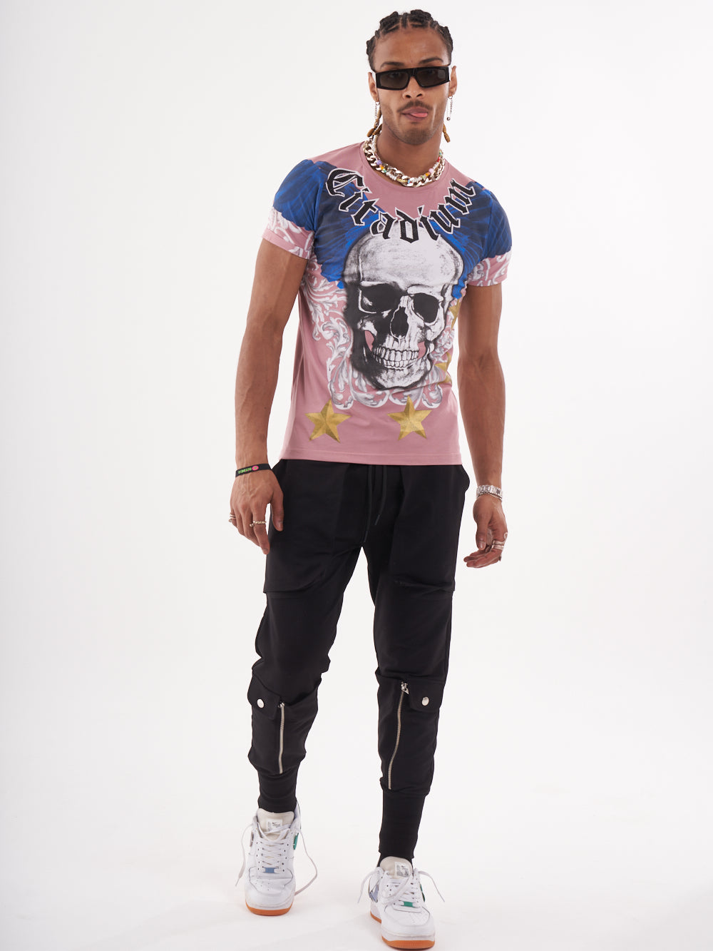 A man wearing a pink EUPHORIA T-SHIRT | MAUVE with a skeleton print, paired with black pants.