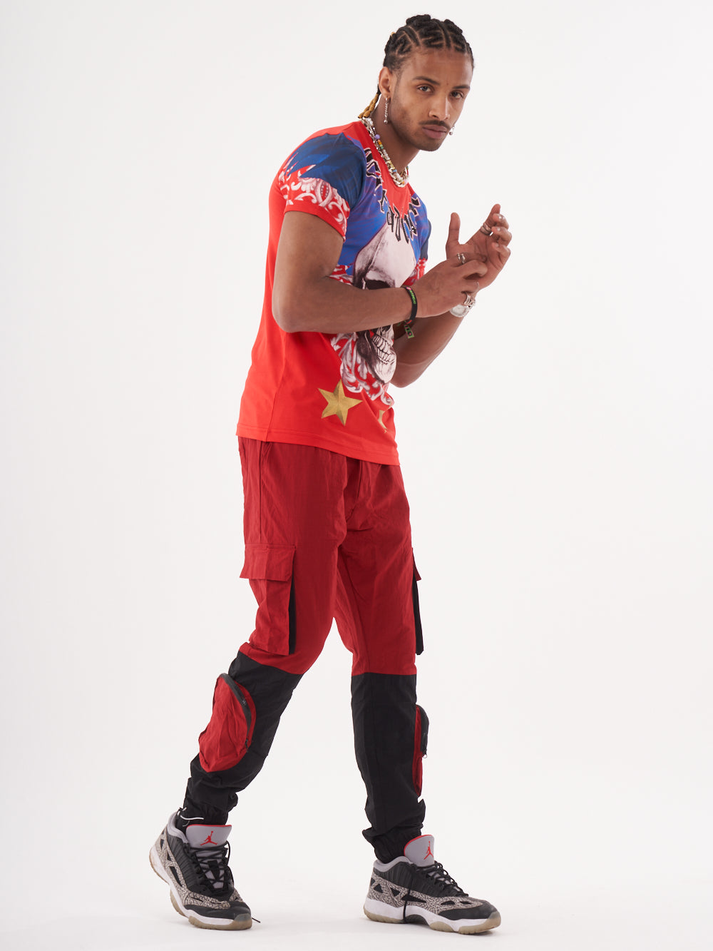 A man sporting a EUPHORIA t-shirt in red, with a bold skeleton print, paired with red cargo pants.