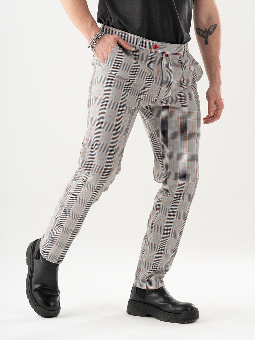 A man in KIKR PANTS and a plaid shirt is posing for a photo.