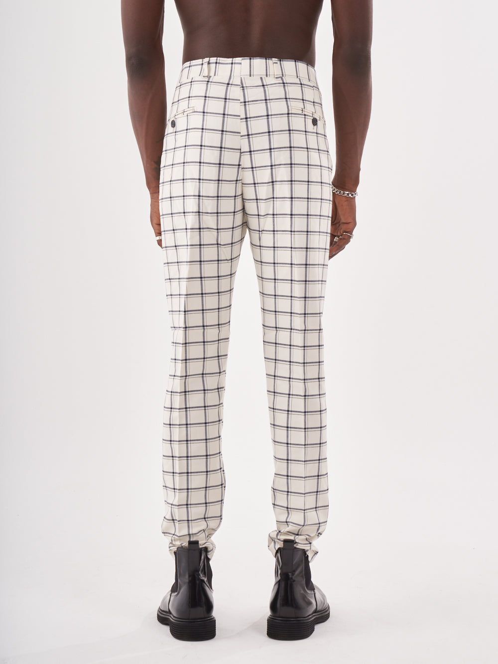 The back view of a man wearing TIMONO pants, a white and black checkered jogger pants.