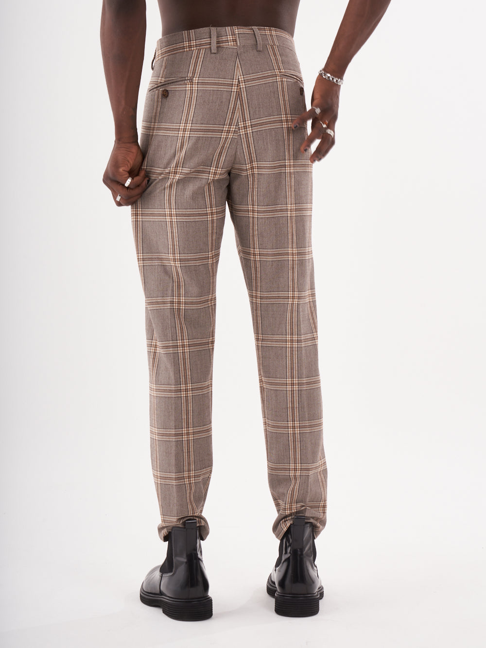 A man wearing [ROOK PANTS] in a brown and tan slim-fit checkered trouser.