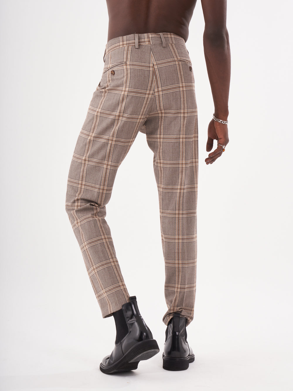 The back of a man wearing brown checkered ROOK PANTS.