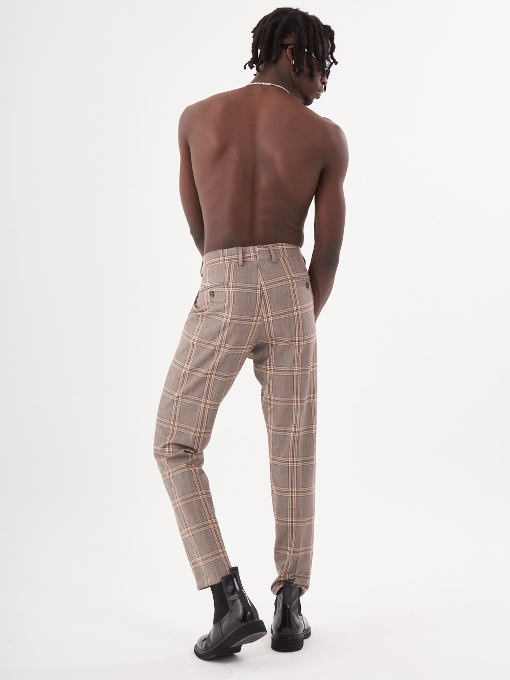 The back view of a man wearing ROOK PANTS.