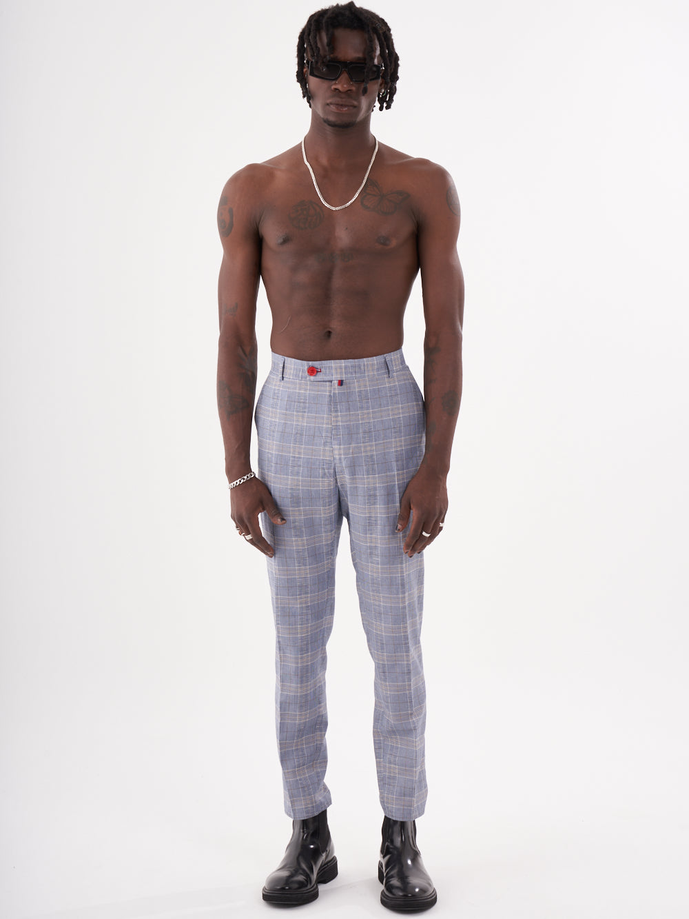 A man with no shirt and Moraine pants is standing in front of a white background.