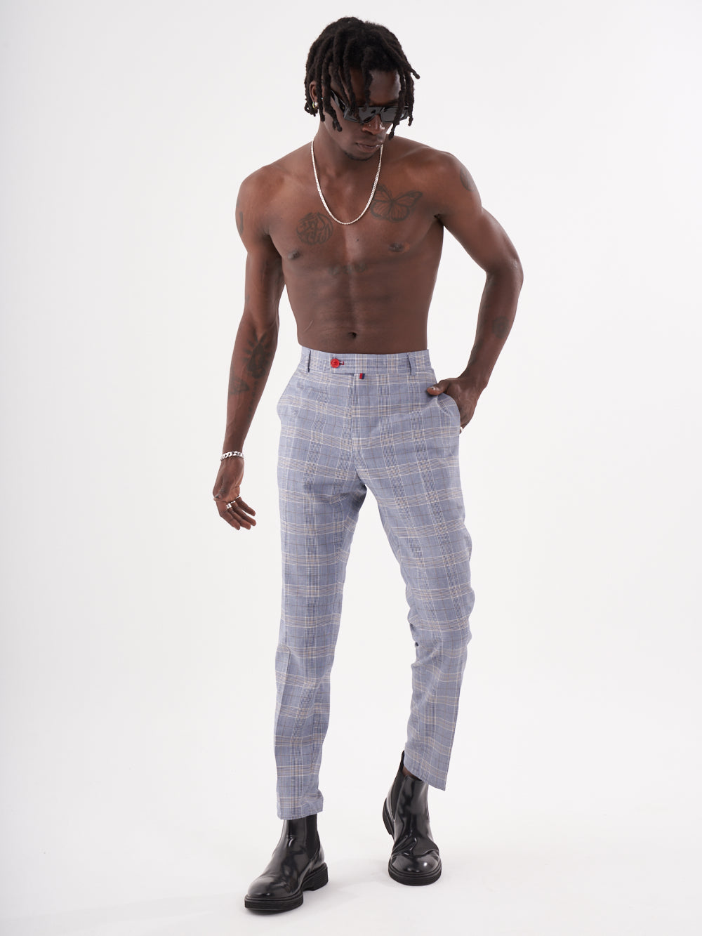 A man with no shirt and no shoes is posing for a photo wearing Moraine pants.