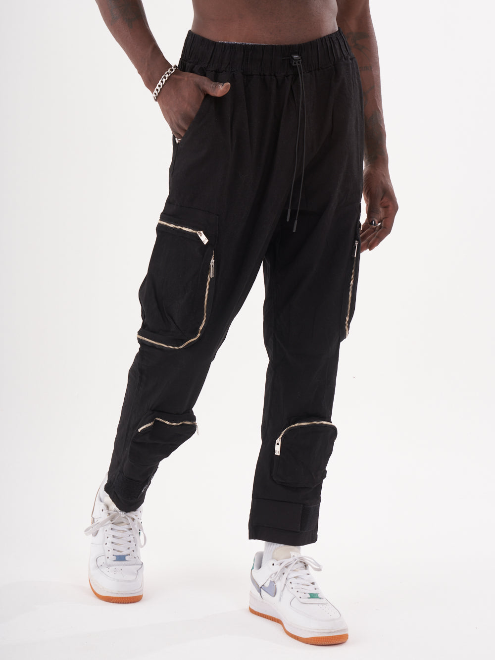 A man wearing Raider joggers with zippers.