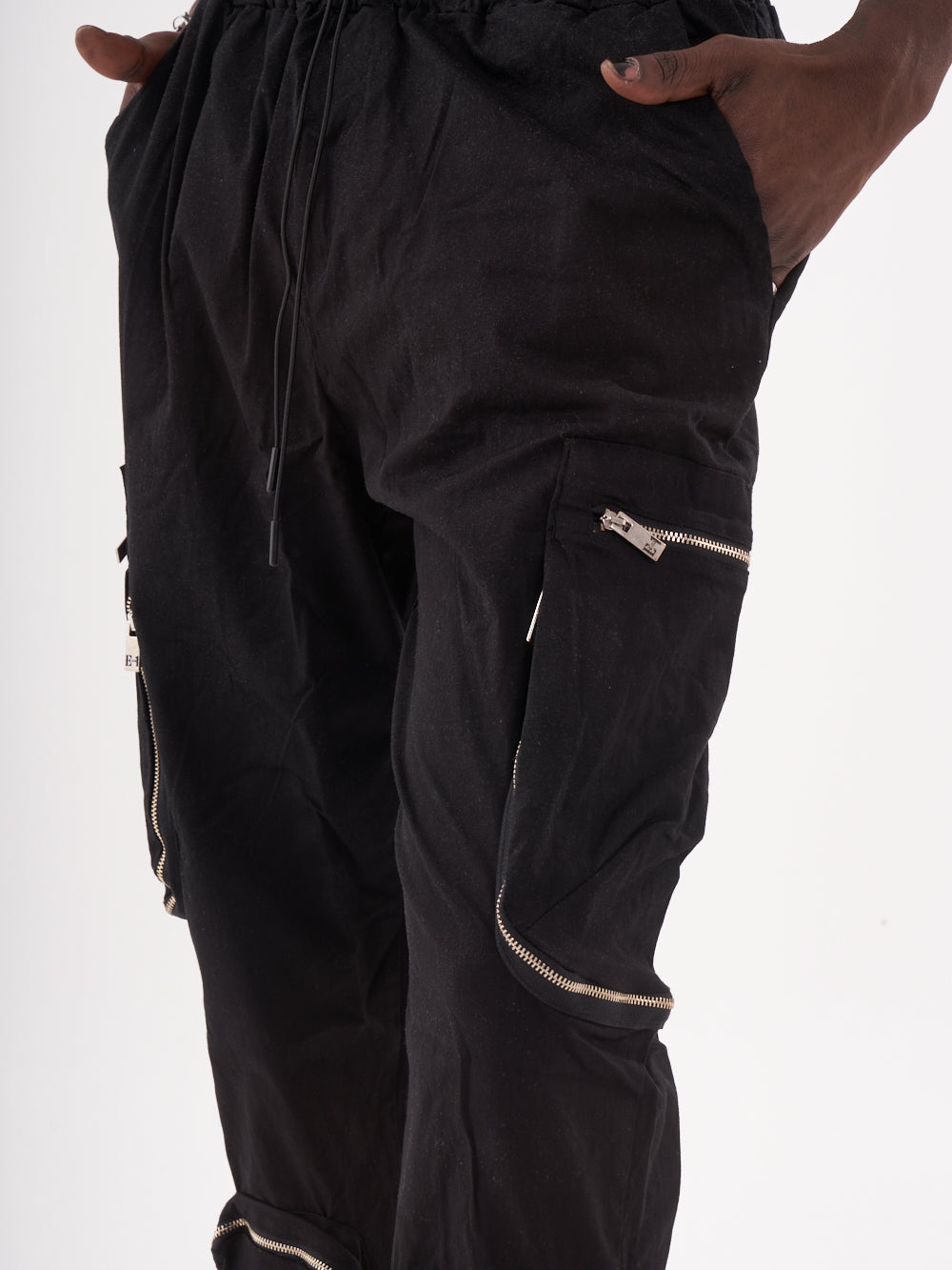 A man wearing black RAIDER JOGGERS with zippers.