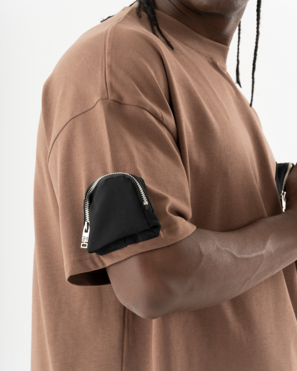 A black man wearing a FATE T-SHIRT with a zippered pocket.