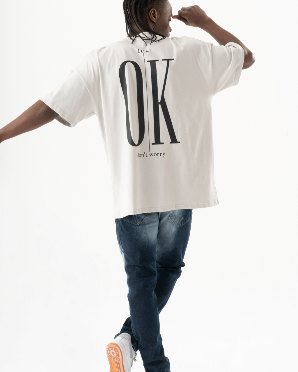 A man wearing an ELEVATE T-SHIRT with the word ok on it.