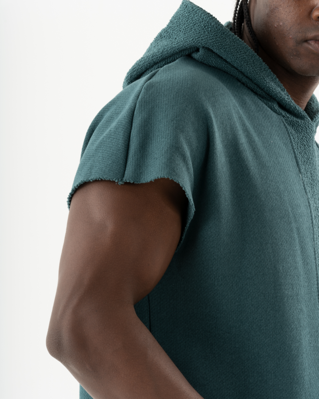 A black man wearing a BACHELOR HOODIE | GREEN with a pouch pocket.