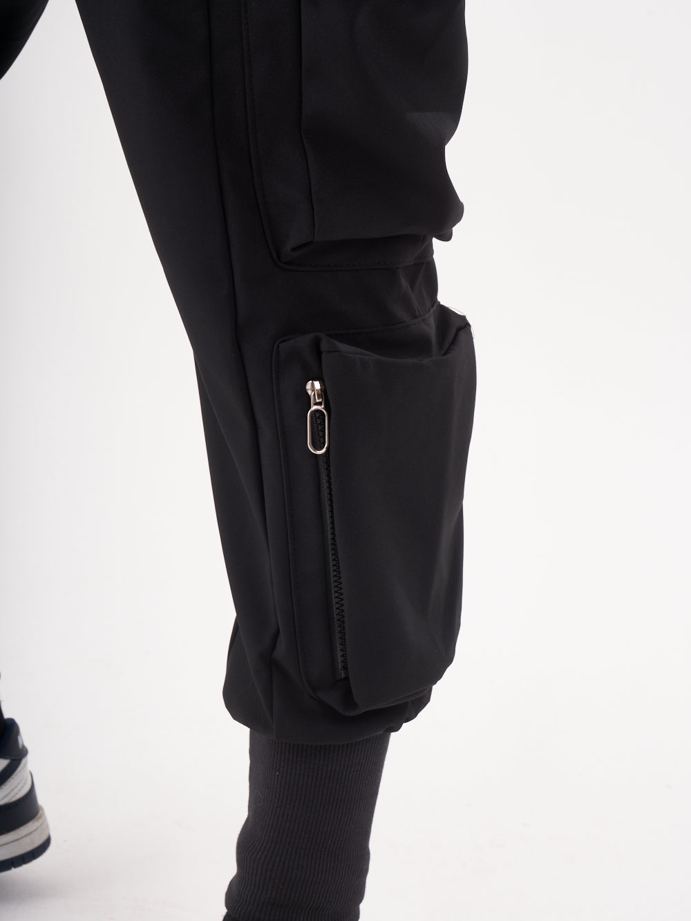 The back of a man wearing OUTLIER JOGGERS | BLACK cargo pants.