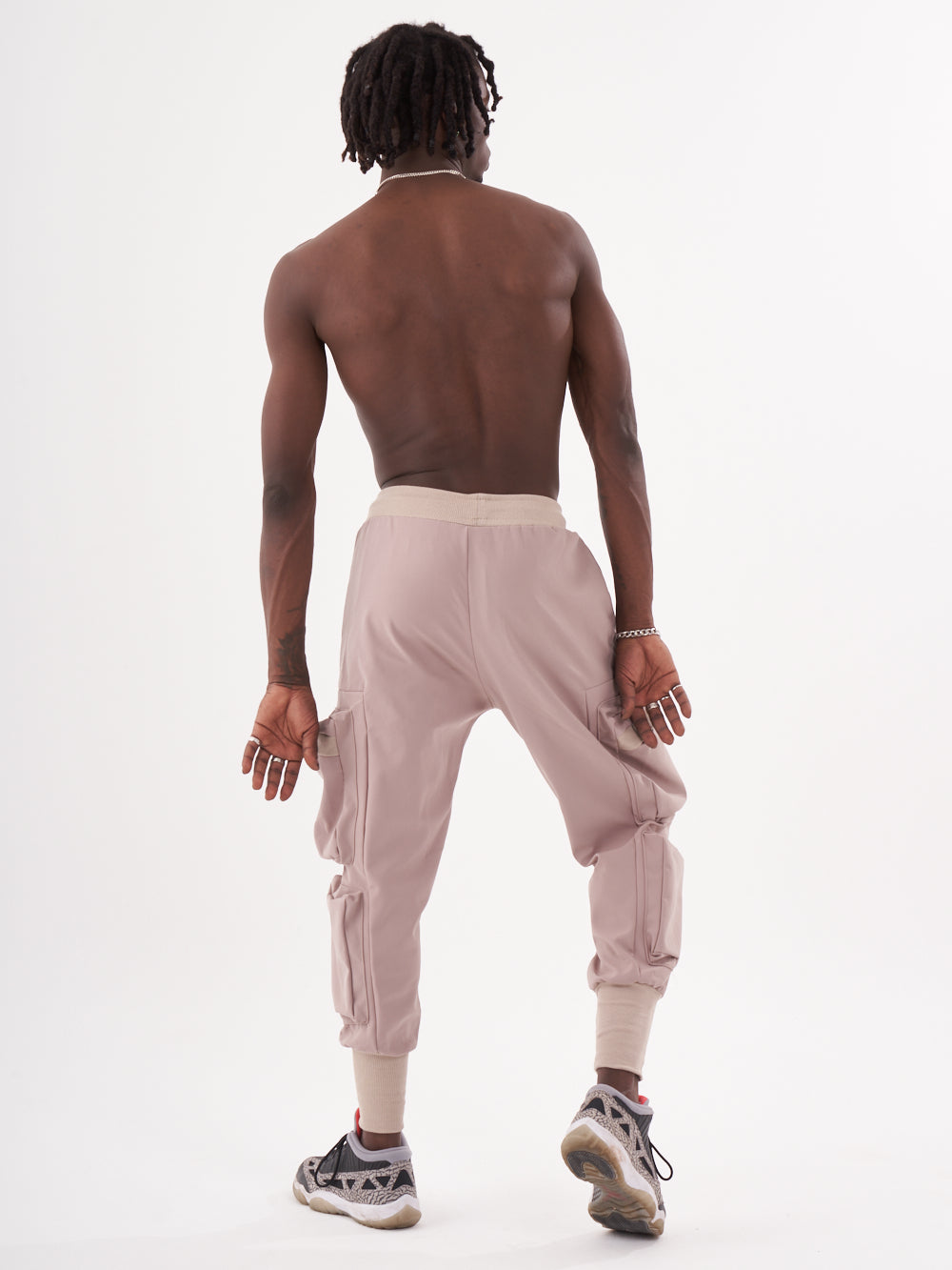 The back view of a man wearing OUTLIER | MAUVE joggers.