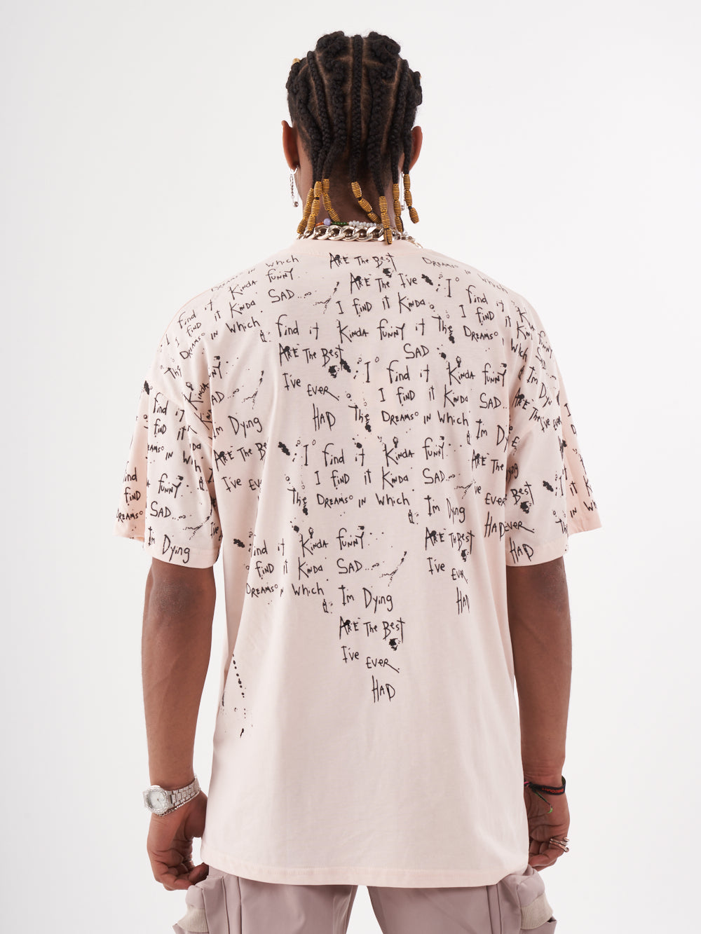The back view of a man wearing a THINKER T-SHIRT with writing on it.