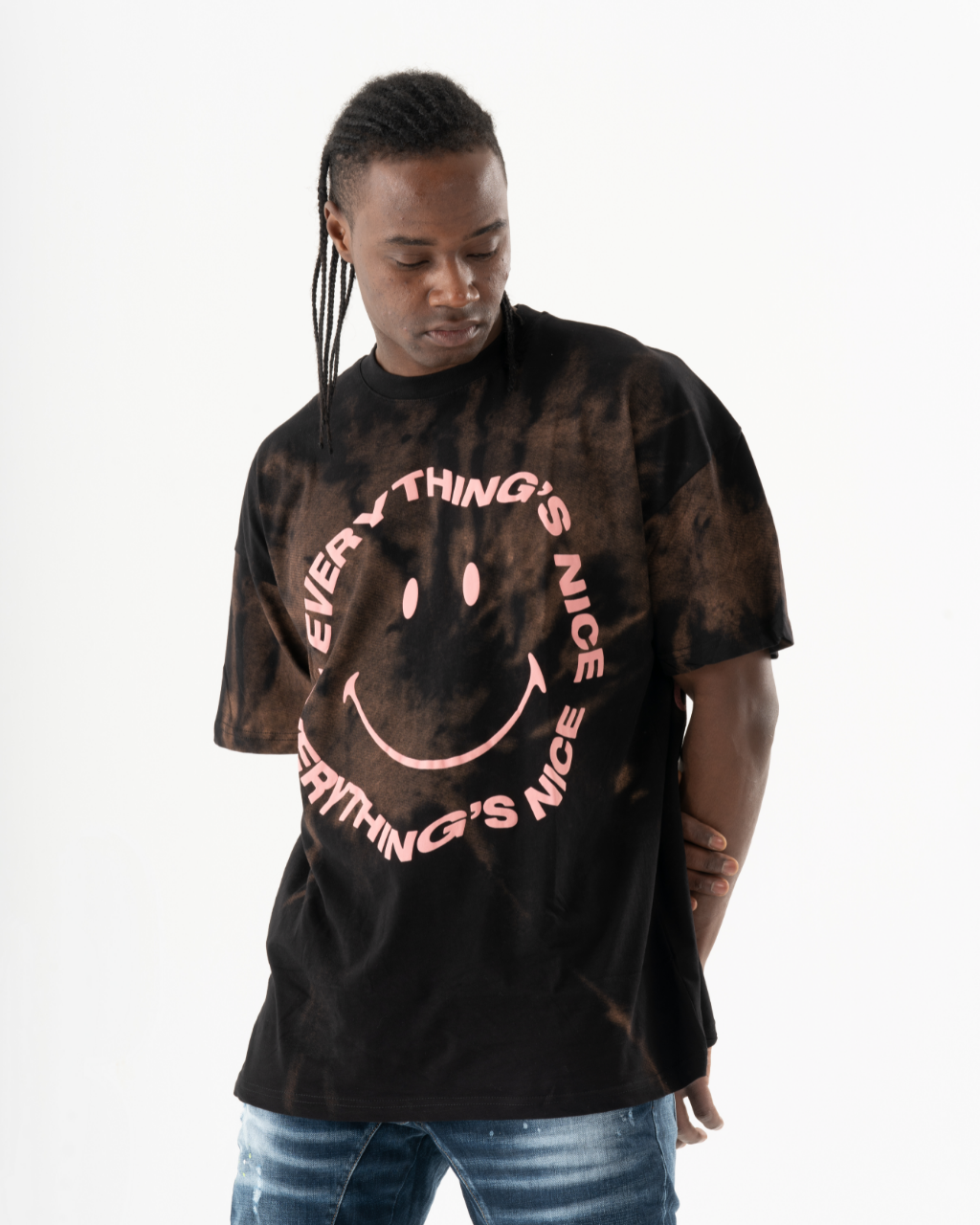 A man wearing an oversize OPTIMIST T-SHIRT with a smiley face on it.