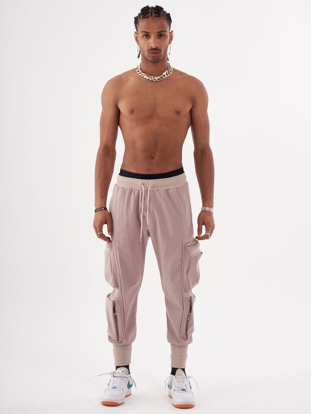 A man in OUTLIER | MAUVE jogging pant is posing for a photo.