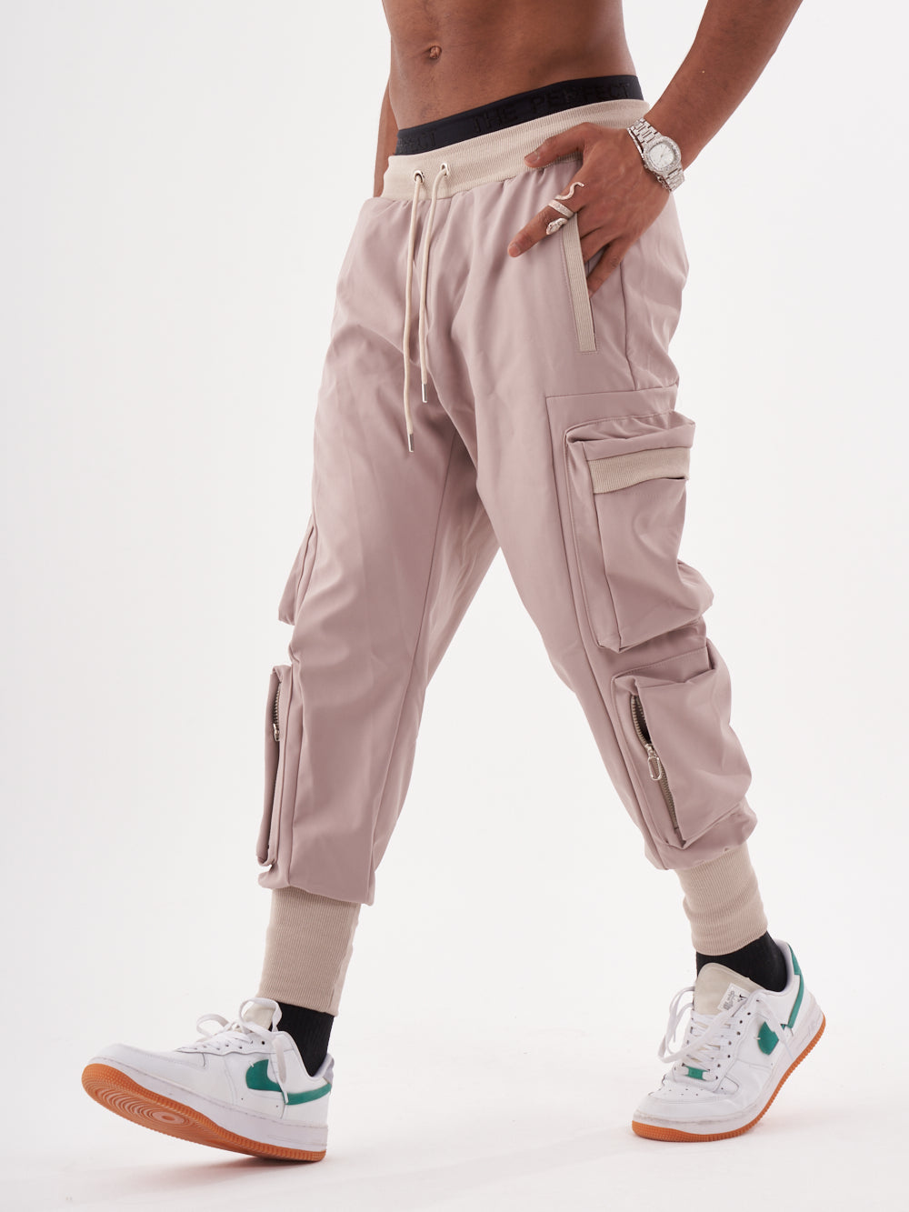 A man wearing OUTLIER | MAUVE cargo pants and sneakers.