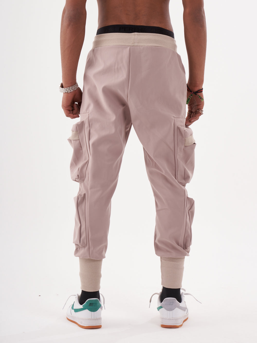 The back view of a man wearing OUTLIER | MAUVE cargo pants.