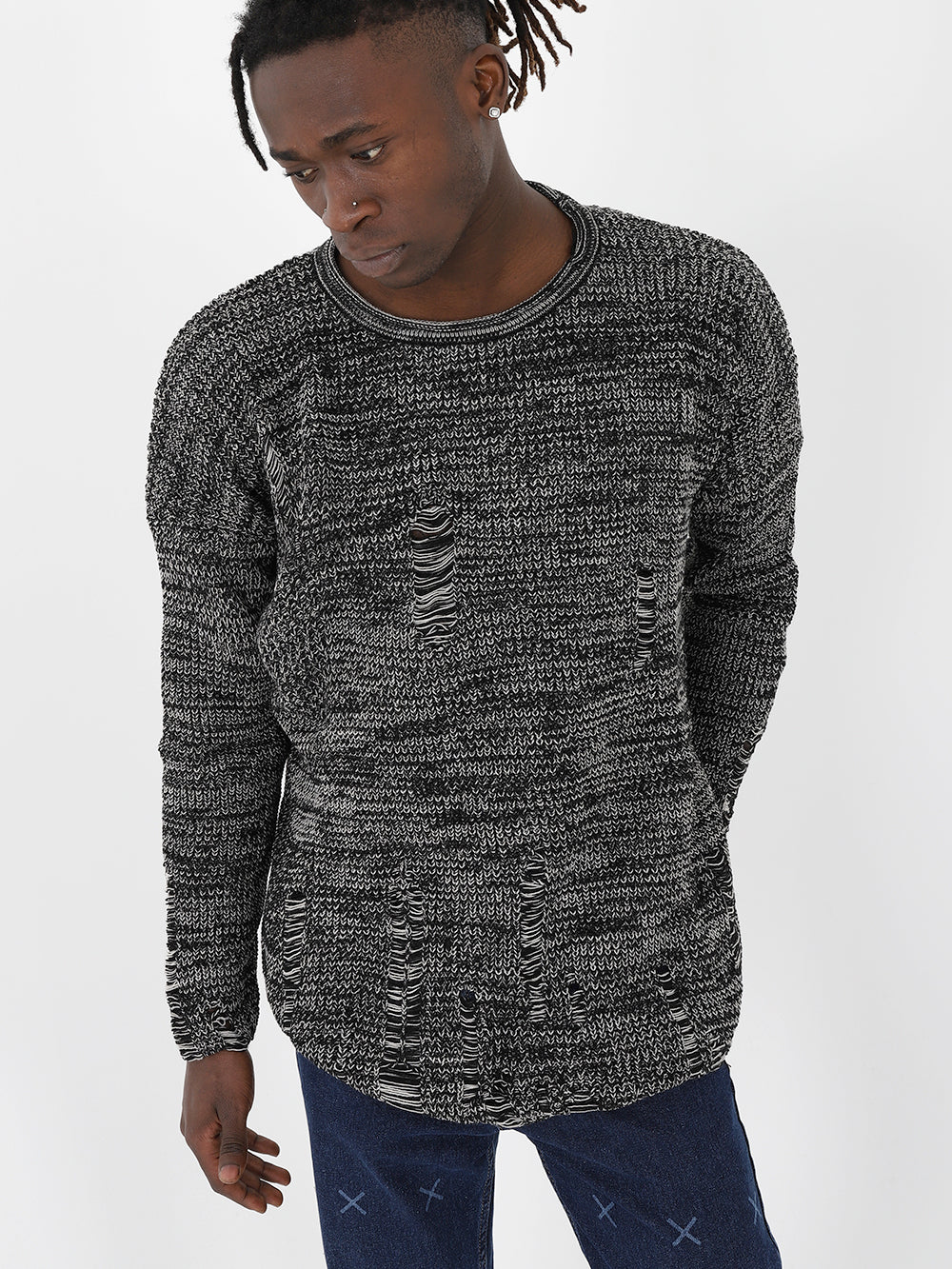 A man wearing a DISTRESSED GENTLEMAN SWEATER | GRAY with true to size fit and jeans.