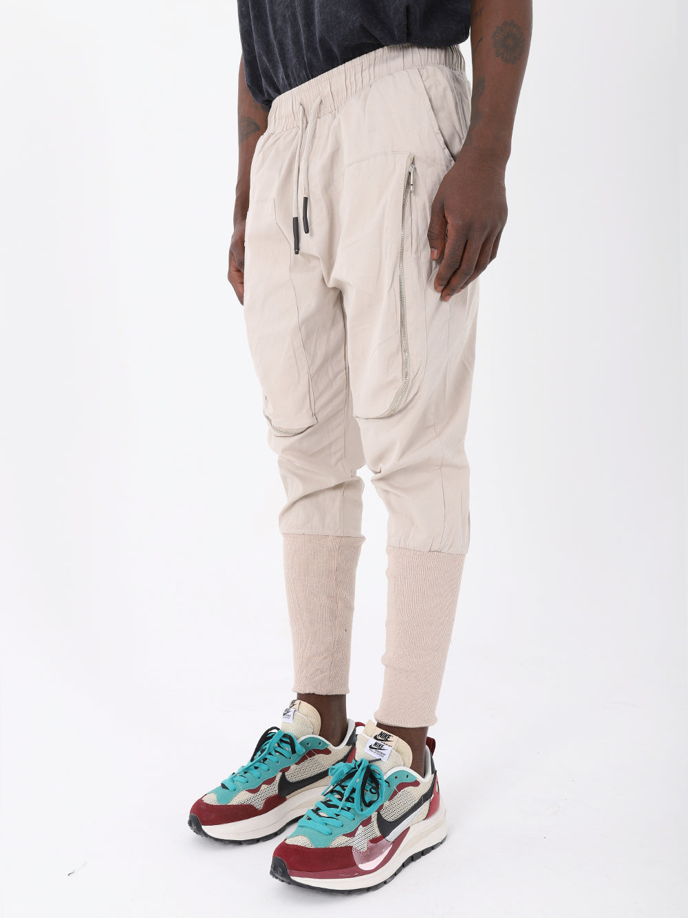 A fashionable man wearing ALTIS JOGGERS with an adjustable drawstring waist, paired with sneakers.