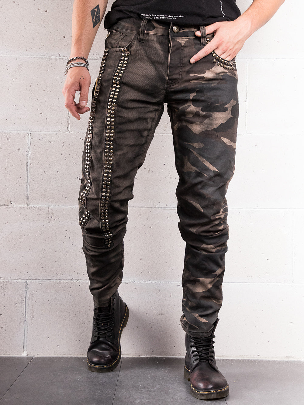 A man wearing SNIPER hand crafted camouflage jeans and a black t-shirt with skinny fit.
