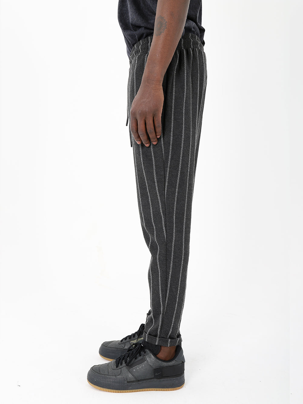 A man wearing a black and white striped POLARITY JOGGERS.