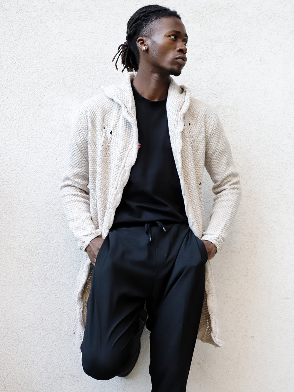 A black man in a white jacket wearing HOODED DISTRESSED CARDIGAN // STONE skinny fit jeans.